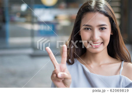 happy girl pointing up 2 fingers; portrait of 62069819