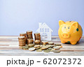 Close up of Wooden home, piggy bank and stack of 62072372