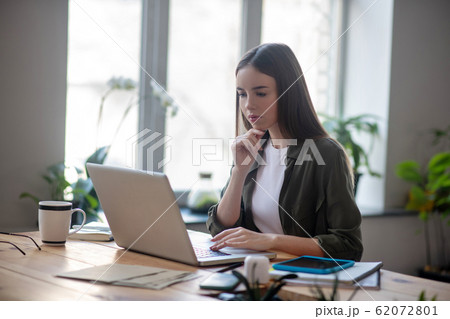 Young smart girl looking at laptop screen. Young smart girl looking at laptop screen. 62072801
