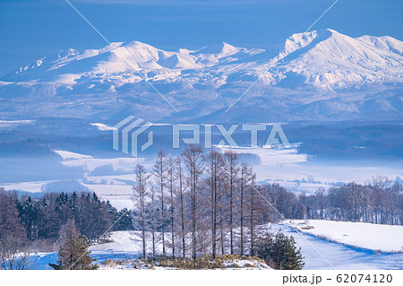 《北海道》冬の北海道・十勝岳連峰と雪原の上富良野 62074120
