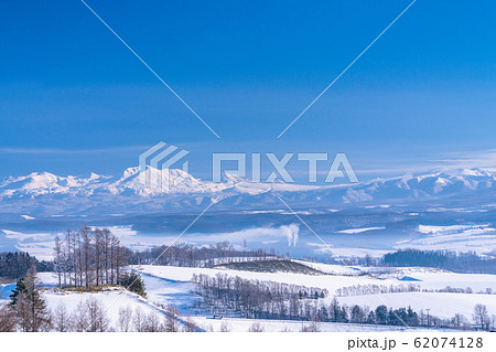 《北海道》冬の北海道・十勝岳連峰と雪原の上富良野 62074128