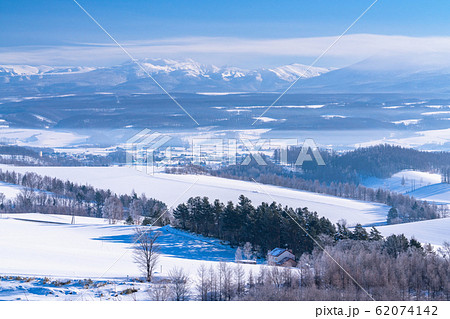 《北海道》冬の北海道・十勝岳連峰と雪原の上富良野 62074142