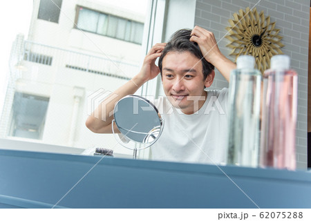 毛髪を気にする若い男子 62075288