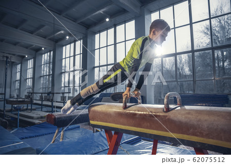Little male gymnast training in gym, flexible and active Little male gymnast training in gym, flexible and active 62075512