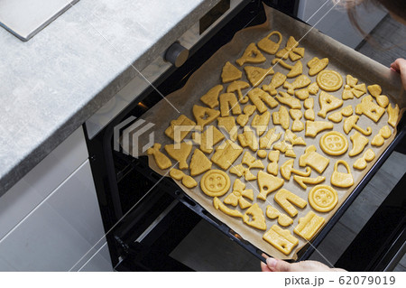 Removing cookies from the oven. Cooking cookies at 62079019