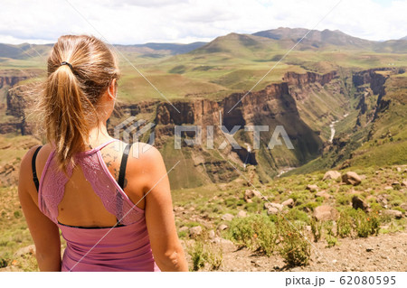 female hiking tourist at the edge of a cliff overlooking the canyons 62080595