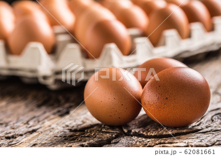 Chicken eggs in carton box on rustic wooden table 62081661