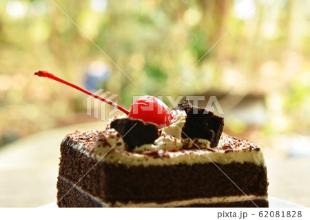 black fotest cake with cream topping cherry on plate black fotest cake with cream topping cherry on plate 62081828