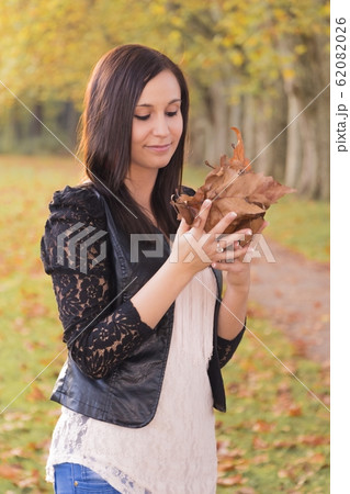 Young woman beauty holding colorful autumn leaves Young woman beauty holding colorful autumn leaves 62082026