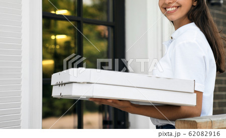 Crop of deliverywoman holding boxes of pizza. 62082916