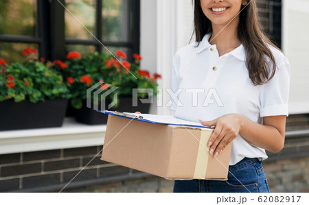 Crop of deliverywoman holding parcel and folder. 62082917