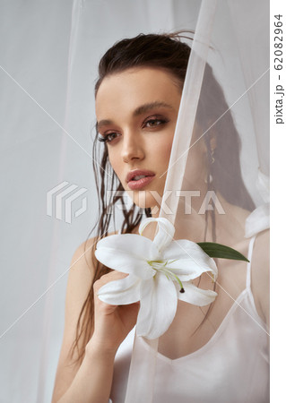 Portrait of girl posing with lily flower. 62082964