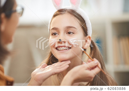 Mother painting her daughter Mother painting her daughter 62083886