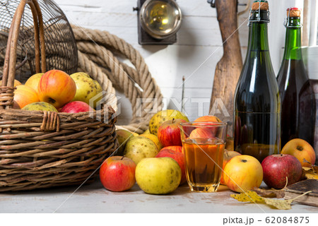 basket of apples, bottles of cider 62084875