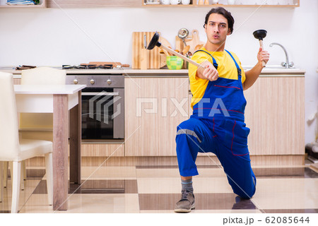 Young male contractor repairing tap at home 62085644