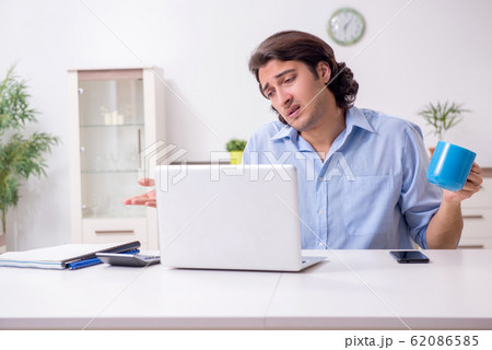 Young male employee working at home 62086585