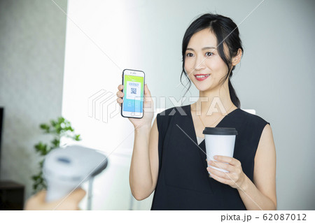 女性　カフェ　スマホ　QR決済　キャッシュレス決済（アプリ画面はピクスタのために作成したダミーです） 62087012