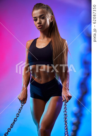 Fit girl posing holding chains. Fit girl posing holding chains. 62087350