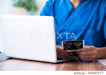 Young male doctor looking at doppler images 62087577