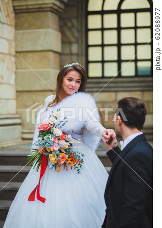 Couple of stylish newlyweds posing on the territory of country hotel 62088977