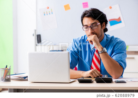 Young male financial manager working in the office Young male financial manager working in the office 62088979