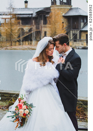 Couple of stylish newlyweds posing on the territory of country hotel Couple of stylish newlyweds posing on the territory of country hotel 62088992