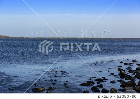 Windmills on a dyke for electric energy in Bruinisse 62090780