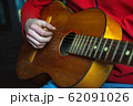 guy musician in red plays an acoustic guitar 62091026