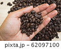 coffee beans hold by hands of man 62097100