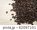pile of coffee beans on wooden background 62097101