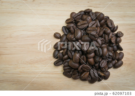 pile of coffee beans on wooden background 62097103