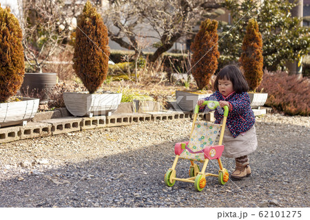 おもちゃのベビーカーを押す女の子 おもちゃのベビーカーを押す女の子 62101275