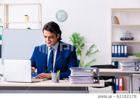Young businessman sitting and working in the office Young businessman sitting and working in the office 62102179