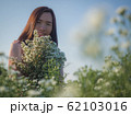 Asian beautiful woman surrounded by flowers 62103016