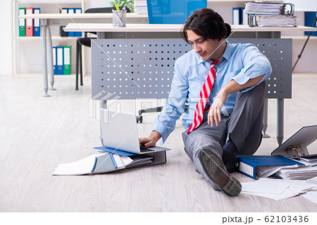 Young male employee unhappy with excessive work 62103436
