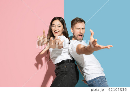 Young emotional man and woman on pink and blue background 62105336