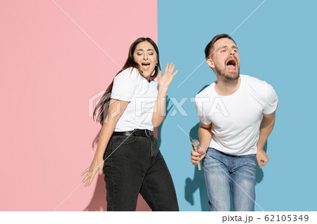 Young emotional man and woman on pink and blue background Young emotional man and woman on pink and blue background 62105349
