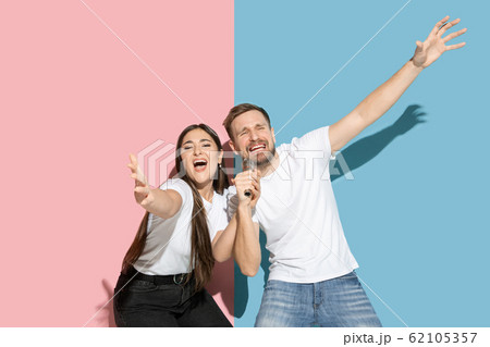 Young emotional man and woman on pink and blue background Young emotional man and woman on pink and blue background 62105357