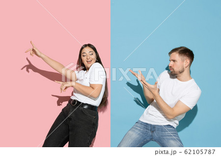Young emotional man and woman on pink and blue background Young emotional man and woman on pink and blue background 62105787