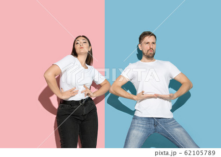 Young emotional man and woman on pink and blue background Young emotional man and woman on pink and blue background 62105789