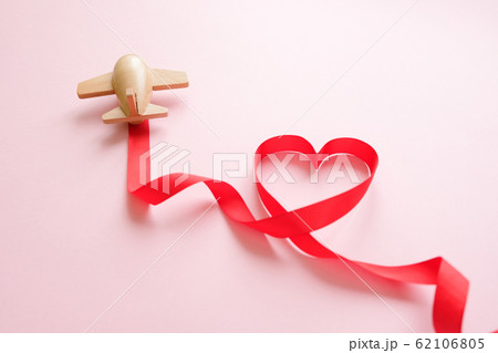 small wooden toy airplane lucky with red ribbon in the shape of heart 62106805