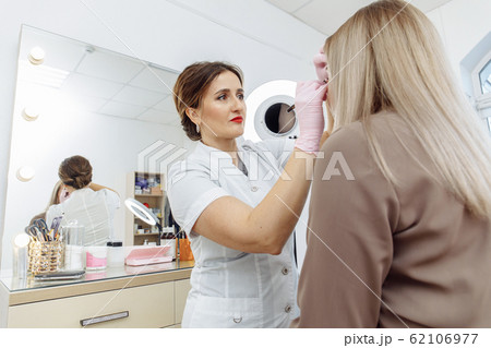 Cosmetologist preparing for permanent makeup, 62106977