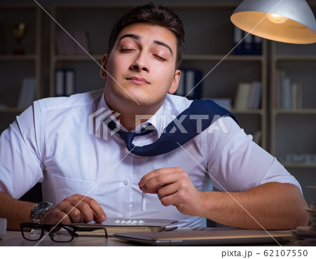 Businessman staying late in office for drugs 62107550