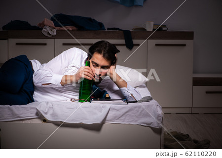 Young employee working at home after night shift 62110220