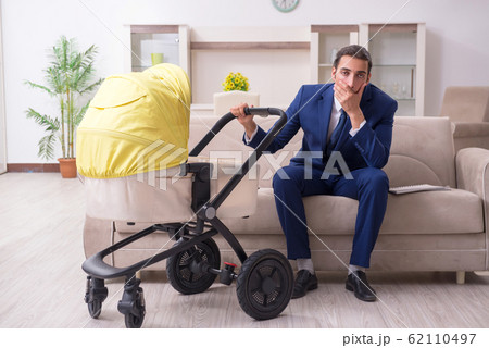 Young businessman looking after baby Young businessman looking after baby 62110497