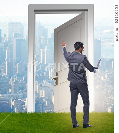 Businessman standing in front of door into future Businessman standing in front of door into future 62110553