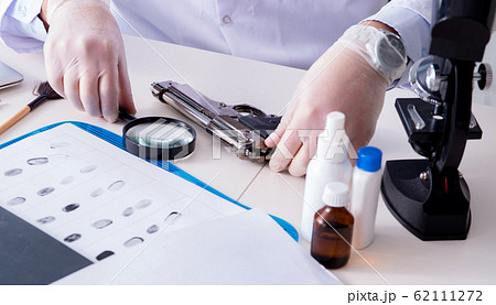 Criminologist police chemist looking at crime evidence 62111272