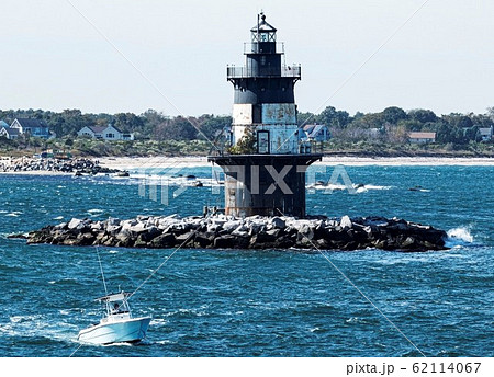 Small boat passing the Orint Point Lighthouse with Small boat passing the Orint Point Lighthouse with 62114067