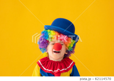 Funny kid clown playing against yellow background 62114570