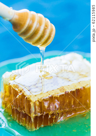 Honey with wooden honey dipper and honeycombs Honey with wooden honey dipper and honeycombs 62115985